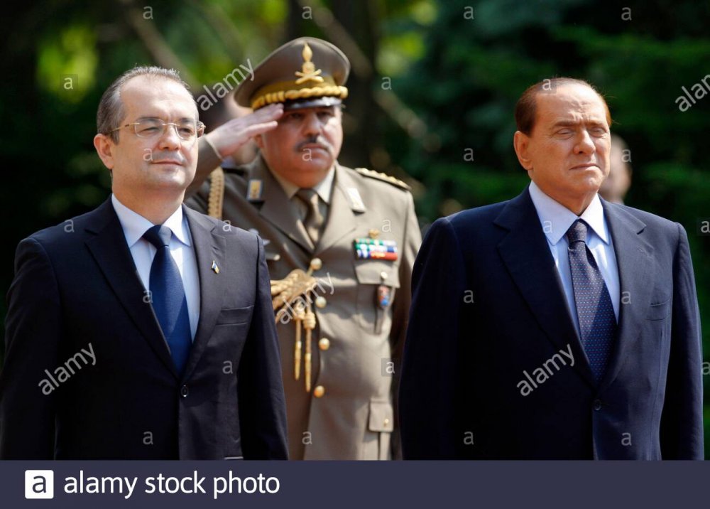 Romania&#39;s Prime Minister Emil Boc (L) and Italy&#39;s Prime Minister Silvio  Berlusconi listen to their national anthems during a welcoming ceremony at  Victoria Palace in Bucharest May 30, 2011. REUTERS/Bogdan Cristel (ROMANIA -