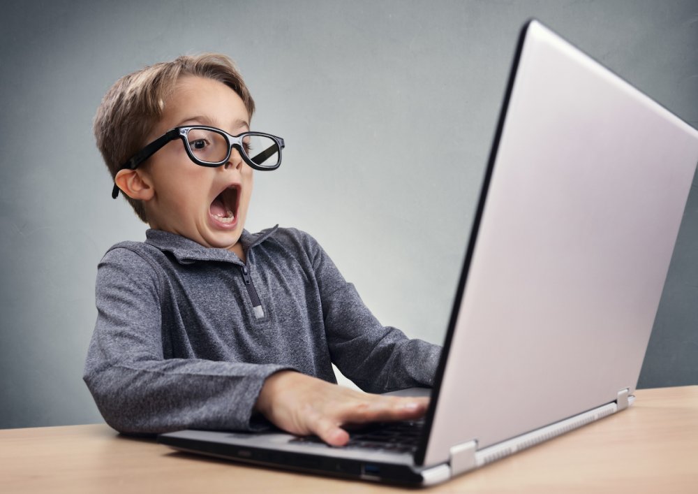 Shocked and surprised boy on the internet with laptop computer concept for  amazement, astonishment, - Children and Screens