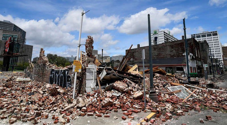 a group of people standing in front of a building: A collapsed jazz shop located at 427 S. Rampart in New Orleans on Monday, Aug. 30, 2021, is seen after Hurricane Ida came ashore in Louisiana on Sunday, Aug. 29, 2021.