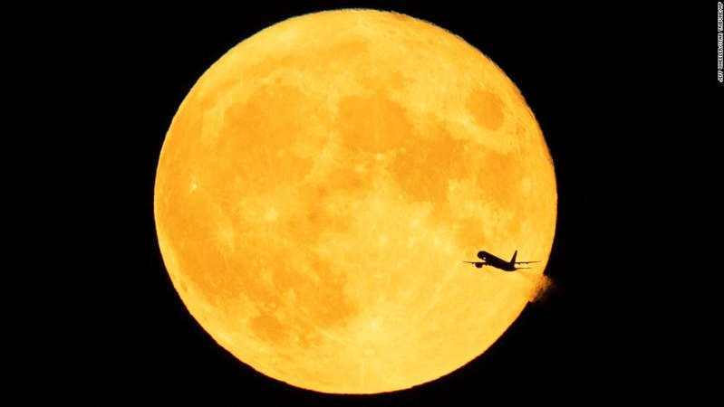 An aircraft passes in front of a Sturgeon moon (true blue moon) after takeoff from Minneapolis-St. Paul International Airport on August 3, 2020.