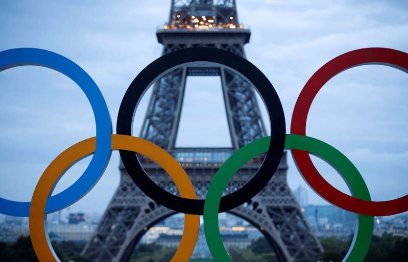 a sign on a metal pole: FILE PHOTO: Olympic rings to celebrate the IOC official announcement that Paris won the 2024 Olympic bid are seen in front of the Eiffel Tower at the Trocadero square in Paris