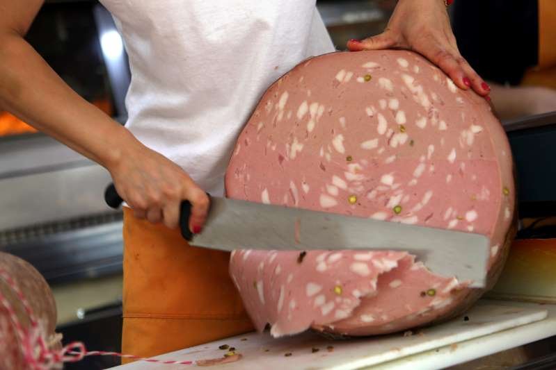 Mortadella salami is sliced by hand at the weekly farmers' market July 25, 2015. Photo by David Silverman/Getty Images