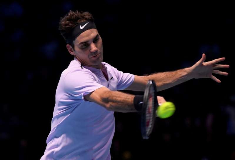 Roger Federer hitting a ball with a racket: FILE PHOTO: Tennis - ATP World Tour Finals