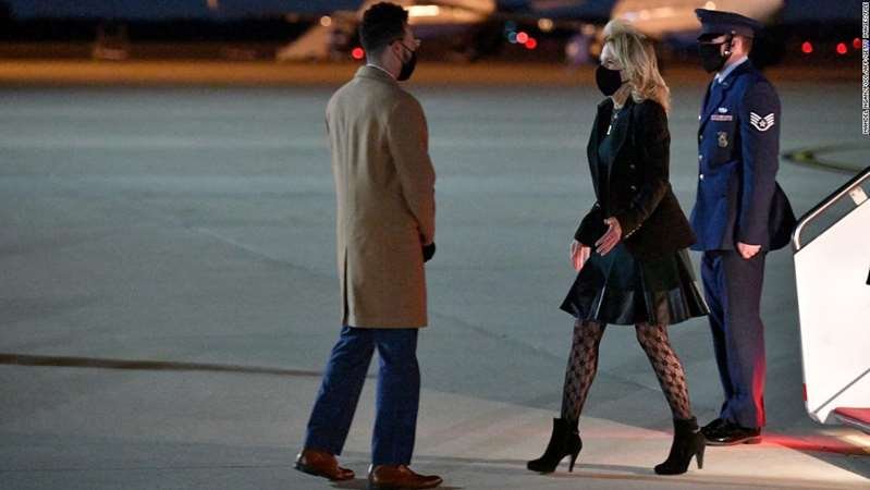 a group of people walking down the street: US First Lady Jill Biden deplanes upon arrival at Andrews Air Force Base in Maryland on April 1, 2021. - Biden returned to Washington after a visit to California. (Photo by MANDEL NGAN / POOL / AFP) (Photo by MANDEL NGAN/POOL/AFP via Getty Images)