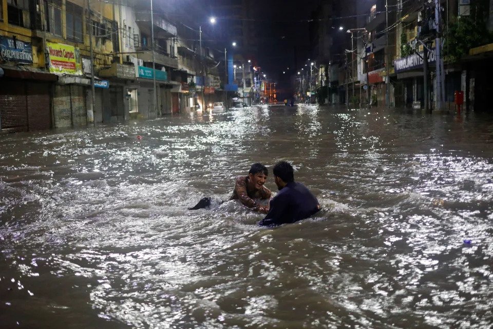 Residents play on a flooded street in Karachi.