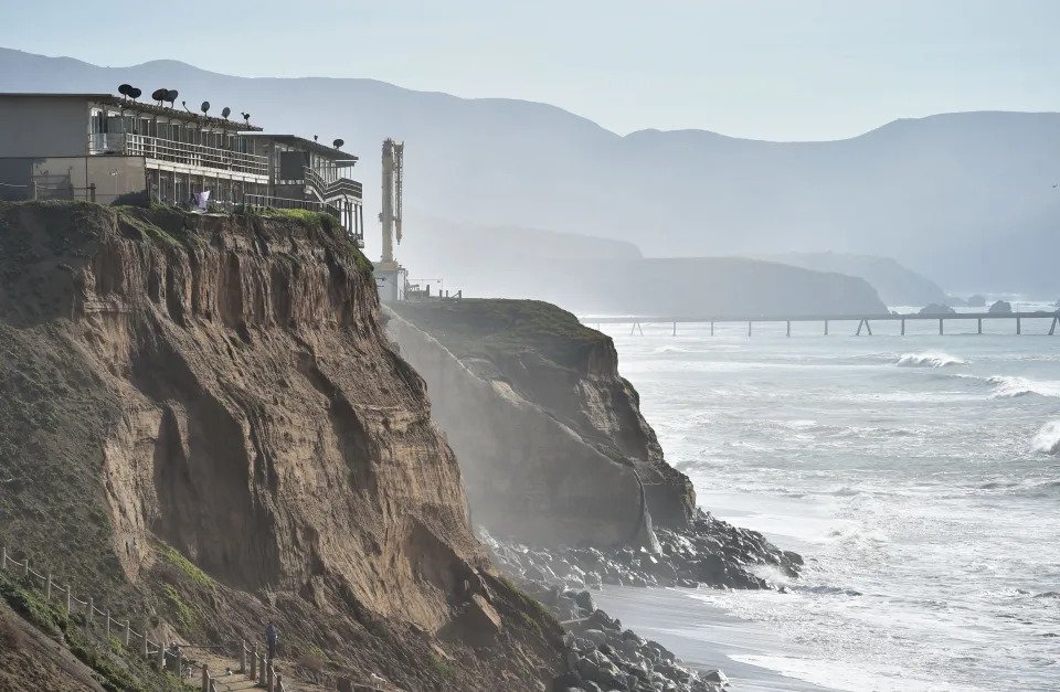 Apartments are seen at the edge of an eroding cliff while residents evacuate in Pacifica, California on January 26, 2016.