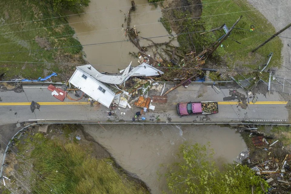 People work to clear a house from a bridge near the Whitesburg Recycling Center in Letcher County, Ky., on Friday, July 29, 2022. (Ryan C. Hermens/Lexington Herald-Leader via AP)